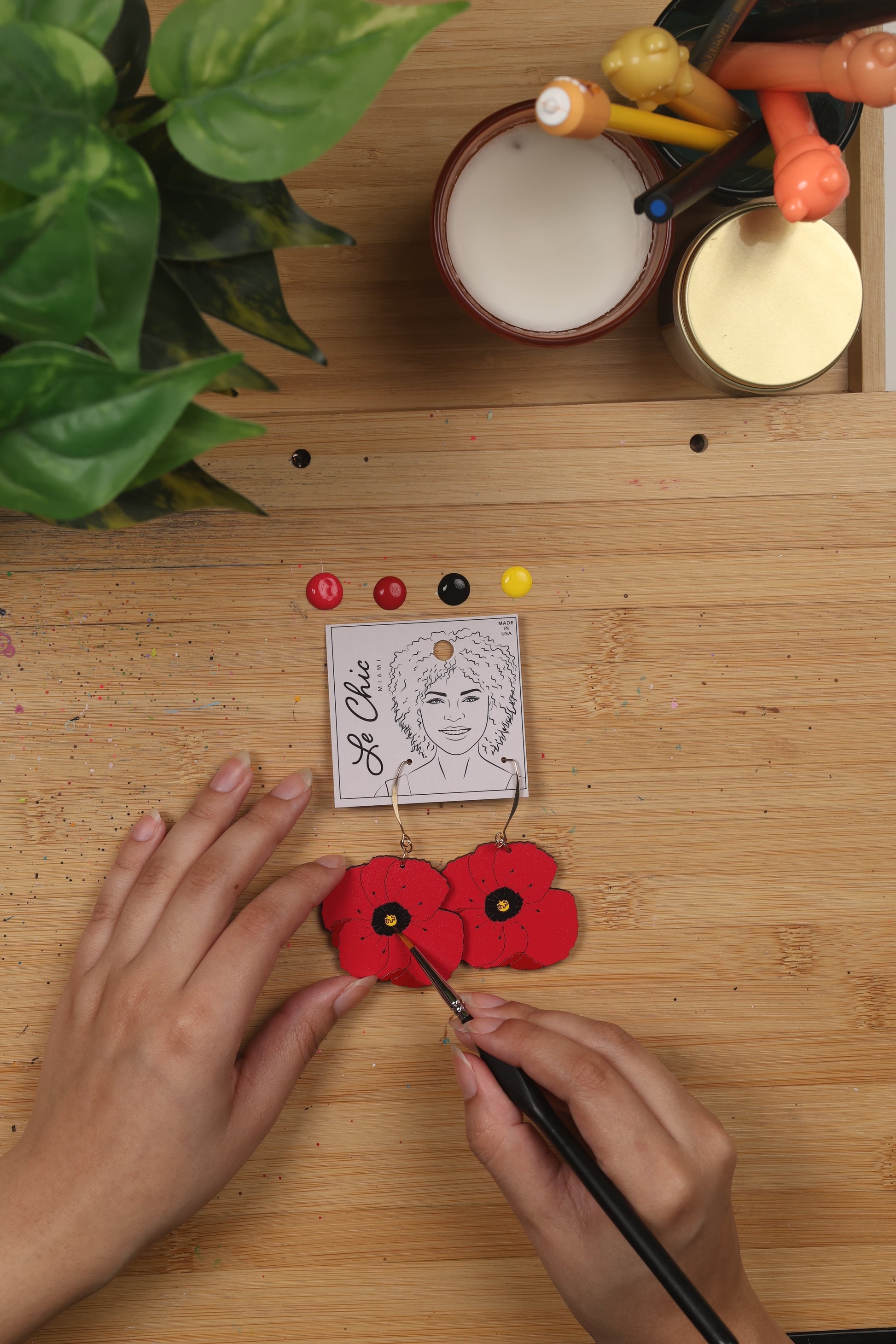 red poppy earring being hand painted - le chic Miami