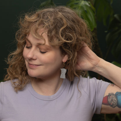 Woman wearing lilac shirt and hand-painted Moka Pot Hoop earring inspired by Cuban coffee, made by Le Chic Miami.